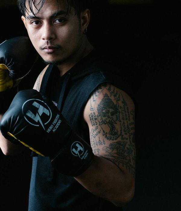 Man in a focused athletic stance against a dark background with light accents.